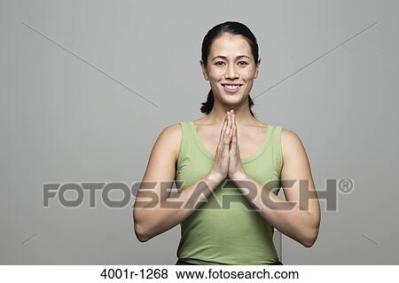 Young woman greeting with folded hands View Large Photo Image Stock Photo - Young woman greeting with folded hands. Fotosearch