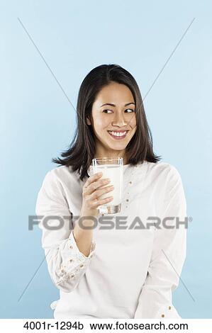 Young woman holding a glass of milk View Large Photo Image Stock Image - Young woman holding a glass of milk. Fotosearch