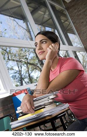Young woman in a classroom with pile of books View Large Photo Image Stock Image - Young woman in a classroom with pile of books. Fotosearch