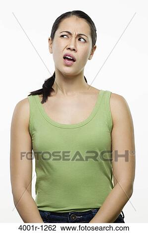 Stock Image - Young woman making a face and thinking. Fotosearch