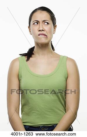 Stock Image - Young woman making a face and thinking. Fotosearch
