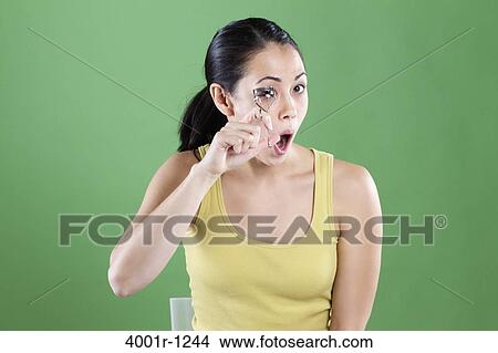 Young woman using an eyelash curler View Large Photo Image Picture - Young woman using an eyelash curler. Fotosearch