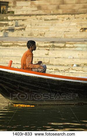 A man fishing in boat in the Ganges River at the holy Hindu city of Varanasi, India in Uttar Pradesh state View Large Photo Image Stock Image - A man fishing in boat in the Ganges River at the holy Hindu city of Varanasi, India in Uttar Pradesh state. Fotosearch