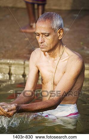 A man ritually bathes in the Ganges River at the Hindu holy city of Varanasi, India in Uttar Pradesh state View Large Photo Image Stock Image - A man ritually bathes in the Ganges River at the Hindu holy city of Varanasi, India in Uttar Pradesh state. Fotosearch