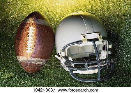 Stock Photo - American football helmet and a football. Fotosearch