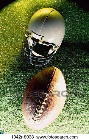 Stock Photo - American football helmet and a football. Fotosearch