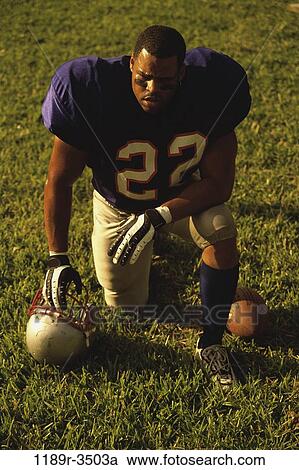 American football player kneeling on the field View Large Photo Image Stock Image - American football player kneeling on the field. Fotosearch