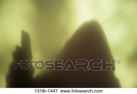 Atmospheric shadow or silhouette of hooded figure holding hand up with two raised joined fingers in blessing Norfolk UK View Large Photo Image Stock Photo - Atmospheric shadow or silhouette of hooded figure holding hand up with two raised joined fingers in blessing Norfolk UK. Fotosearch