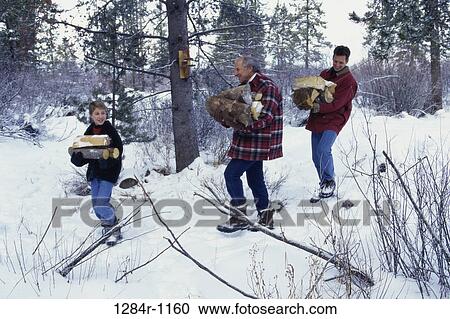 Stock Image - Boy collecting firewood with his father and grandfather. Fotosearch