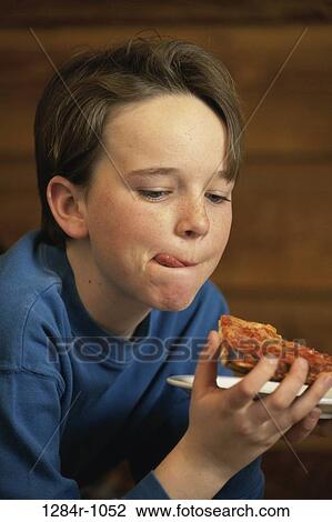 Stock Image - Boy eating a slice of pizza. Fotosearch