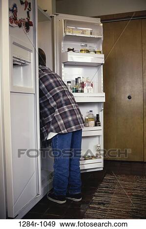 Boy looking into a refrigerator View Large Photo Image Stock Photo - Boy looking into a refrigerator. Fotosearch