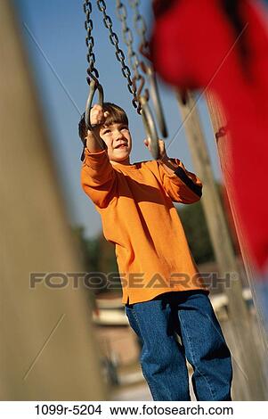 Boy playing on a jungle gym View Large Photo Image Picture - Boy playing on a jungle gym. Fotosearch