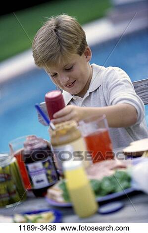 Boy sitting at poolside View Large Photo Image Stock Photo - Boy sitting at poolside. Fotosearch