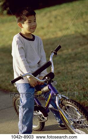 Stock Image - Boy sitting on a bicycle. Fotosearch