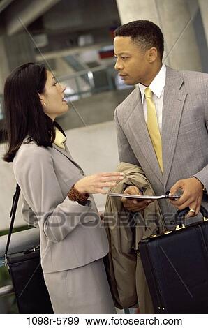 Stock Photo - Businessman and a businesswoman talking. Fotosearch