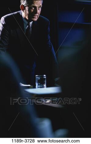 Businessman leaning against a desk View Large Photo Image Stock Photo - Businessman leaning against a desk. Fotosearch