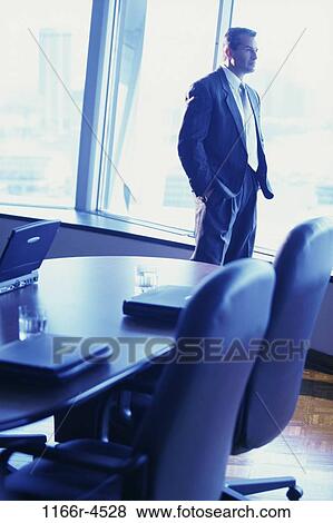 Stock Photo - Businessman looking through a window. Fotosearch