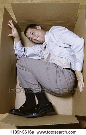Businessman lying in a cardboard box View Large Photo Image Stock Image - Businessman lying in a cardboard box. Fotosearch
