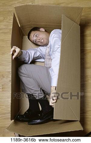 Businessman lying in a cardboard box View Large Photo Image Stock Image - Businessman lying in a cardboard box. Fotosearch
