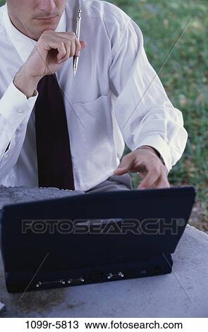 Stock Image - Businessman sitting in front of a laptop. Fotosearch