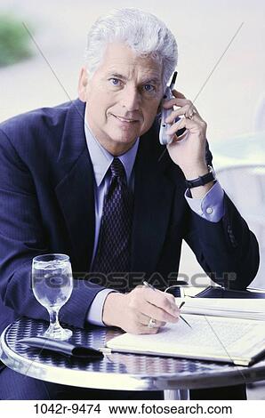 Businessman sitting talking on a mobile phone View Large Photo Image Picture - Businessman sitting talking on a mobile phone. Fotosearch