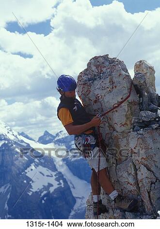Canada, Alberta, Banff National Park, mountaineer securing rope around rock pinnacle before rappelling (abseiling) View Large Photo Image Picture - Canada, Alberta, Banff National Park, mountaineer securing rope around rock pinnacle before rappelling (abseiling). Fotosearch