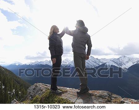 Canada, Alberta, Banff National Park, Couple exchanging high-fives on mountain summit View Large Photo Image Stock Image - Canada, Alberta, Banff National Park, Couple exchanging high-fives on mountain summit. Fotosearch