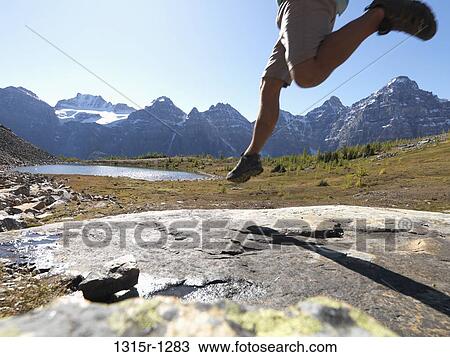 Canada, Alberta, Banff National Park, hiker jumping across rock slab in meadow View Large Photo Image Stock Image - Canada, Alberta, Banff National Park, hiker jumping across rock slab in meadow. Fotosearch