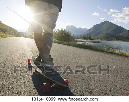 Canada, Alberta, Banff National Park, low section of skateboarder gliding on mountain road View Large Photo Image Stock Photo - Canada, Alberta, Banff National Park, low section of skateboarder gliding on mountain road. Fotosearch