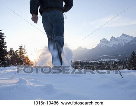 Canada, Alberta, Banff National Park, Man running through snow on cold winter's day View Large Photo Image Stock Photograph - Canada, Alberta, Banff National Park, Man running through snow on cold winter's day. Fotosearch