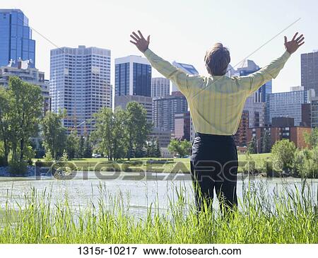 Canada, Alberta, Calgary, Businessman standing at edge of river with arms outstretched View Large Photo Image Stock Photo - Canada, Alberta, Calgary, Businessman standing at edge of river with arms outstretched. Fotosearch