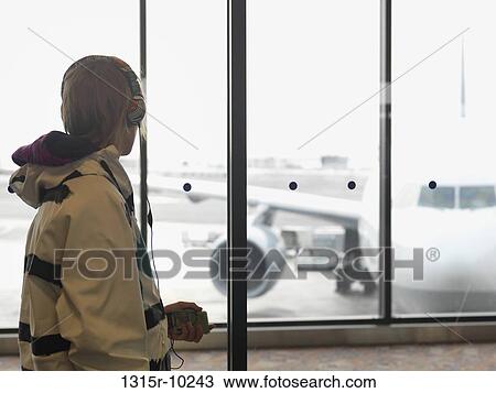 Canada, Alberta, Calgary, Teenage boy listening to mp3 player at airport View Large Photo Image Stock Image - Canada, Alberta, Calgary, Teenage boy listening to mp3 player at airport. Fotosearch