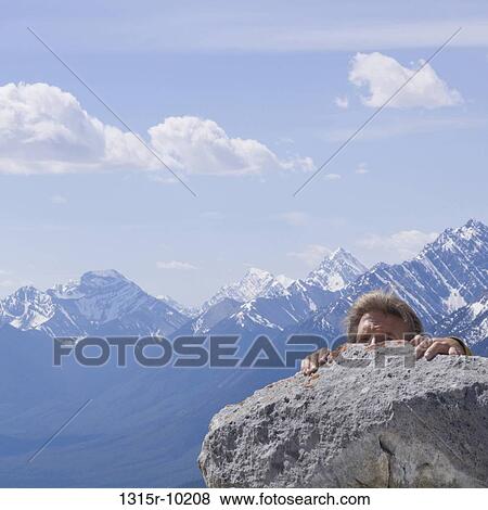 Stock Photo - Canada, Alberta, Climber reaching summit of mountain. Fotosearch