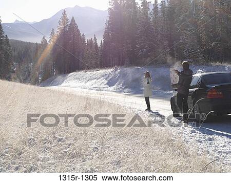 Canada, Alberta, couple consulting map at edge of mountain road View Large Photo Image Stock Photography - Canada, Alberta, couple consulting map at edge of mountain road. Fotosearch