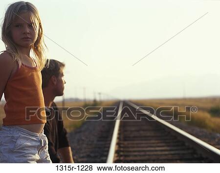 Canada, Alberta, Father and daughter waiting at edge of railway tracks View Large Photo Image Stock Photo - Canada, Alberta, Father and daughter waiting at edge of railway tracks. Fotosearch