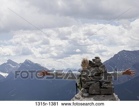 Canada, Alberta, hiker raising arms on mountain summit View Large Photo Image Stock Image - Canada, Alberta, hiker raising arms on mountain summit. Fotosearch