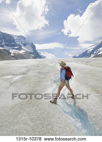 Canada, Alberta, Jasper National Park, Hiker straddling glacial stream in Columbia Icefields View Large Photo Image Stock Photo - Canada, Alberta, Jasper National Park, Hiker straddling glacial stream in Columbia Icefields. Fotosearch
