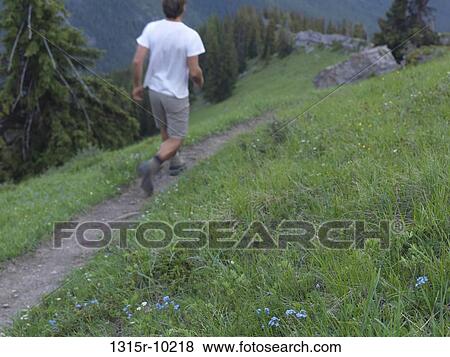 Canada, Alberta, Man running along mountain trail View Large Photo Image Stock Photo - Canada, Alberta, Man running along mountain trail. Fotosearch