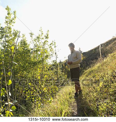 Canada, Alberta, Man sending text message on trail View Large Photo Image Stock Image - Canada, Alberta, Man sending text message on trail. Fotosearch
