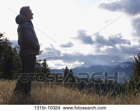 Canada, Alberta, Man standing in mountain meadow View Large Photo Image Picture - Canada, Alberta, Man standing in mountain meadow. Fotosearch
