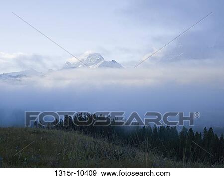 Canada, Alberta, Mountains covered with early morning fog View Large Photo Image Stock Photo - Canada, Alberta, Mountains covered with early morning fog. Fotosearch