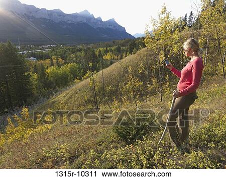 Canada, Alberta, Woman sending text message on hillside above Canmore View Large Photo Image Stock Image - Canada, Alberta, Woman sending text message on hillside above Canmore. Fotosearch