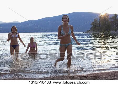 Canada, British Columbia, Woman with two teenage daughters running from Okanagan Lake at sunset View Large Photo Image Stock Image - Canada, British Columbia, Woman with two teenage daughters running from Okanagan Lake at sunset. Fotosearch