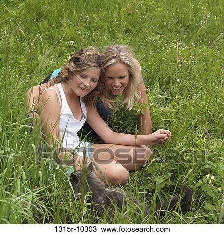 Canada, Mother and daughter play with cat in meadow View Large Photo Image Stock Image - Canada, Mother and daughter play with cat in meadow. Fotosearch