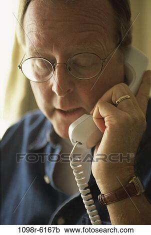 Close-up of a mature man talking on a telephone View Large Photo Image Stock Image - Close-up of a mature man talking on a telephone. Fotosearch