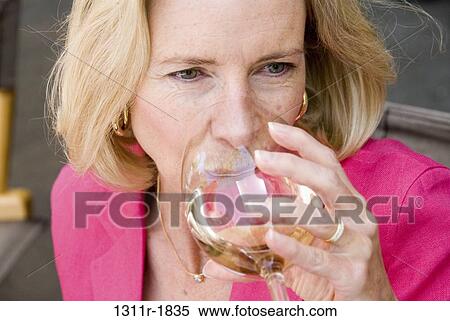 Stock Photography - Close-up of a mature woman drinking wine. Fotosearch