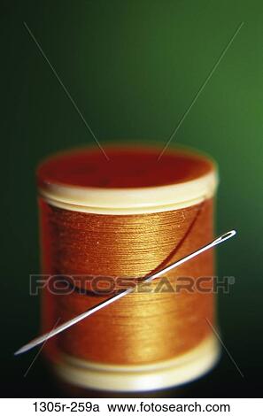 Stock Image - Close-up of a needle and a spool of thread. Fotosearch