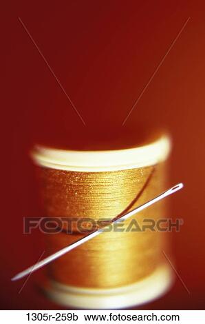Stock Image - Close-up of a needle and a spool of thread. Fotosearch