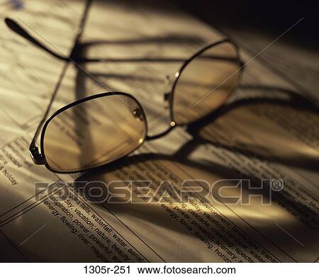 Stock Image - Close-up of a pair of eyeglasses on a book. Fotosearch
