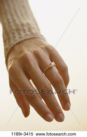 Close-up of a person's finger with a diamond ring View Large Photo Image Stock Photography - Close-up of a person's finger with a diamond ring. Fotosearch